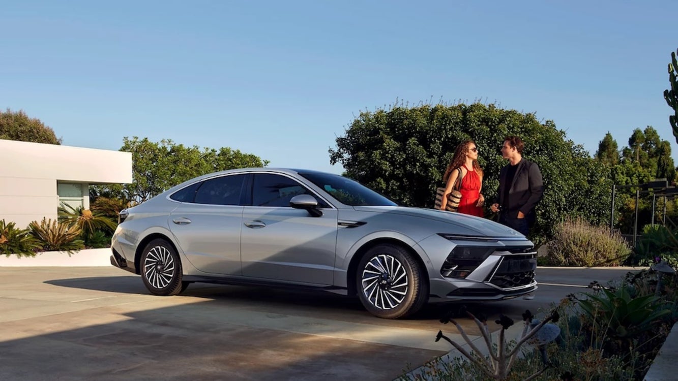 A couple standing beside a silver 2026 Hyundai Sonata sedan