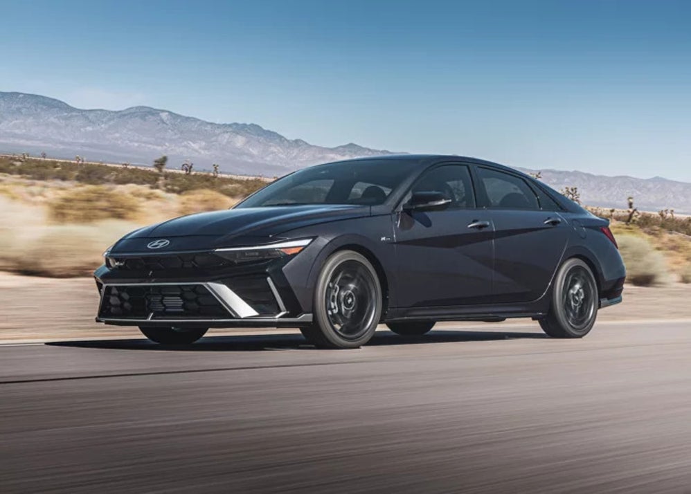 A gray 2025 Hyundai Elantra sedan driving down a desert road