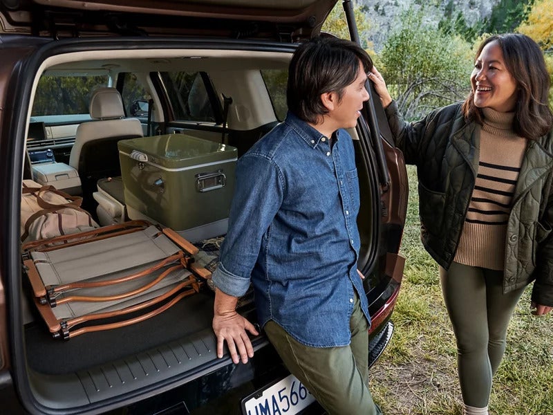 Two people talking beside the open trunk of a 2026 Hyundai Santa Fe SUV